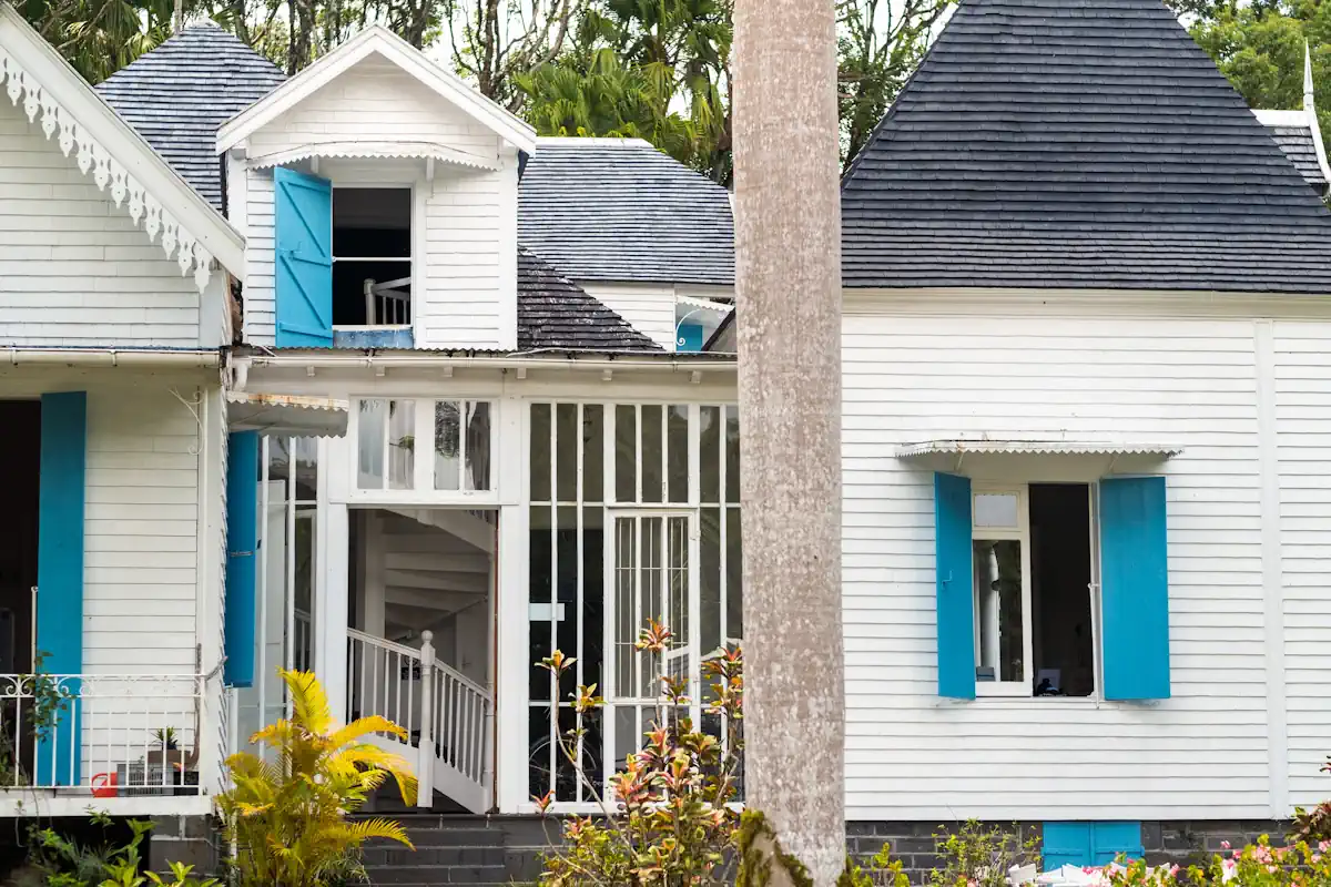 Une maison en bois de style colonial avec les volets ouverts