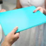 Une femme qui prend un dossier bleu en main
