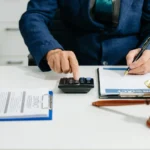 Un homme qui fait des calculs devant une balance de la justice