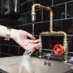 Une femme qui passe la main sous un robinet qui laisse couler de l'eau