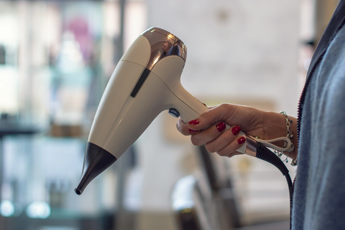 Une personne qui tient un sèche-cheveux