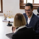 Un homme et une femme qui discute autour d'une table où est posé la balance de la justice