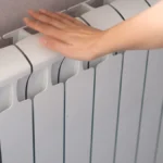 Une main posée sur un radiateur chauffant
