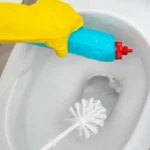 Une personne qui nettoie des toilettes avec des produits et un balais