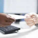 Pourquoi les bailleurs exigent-ils 3 quittances de loyer ? Un homme qui tend un document à un autre