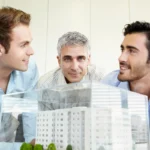 Un groupe d'amis qui regarde une maquette de maison