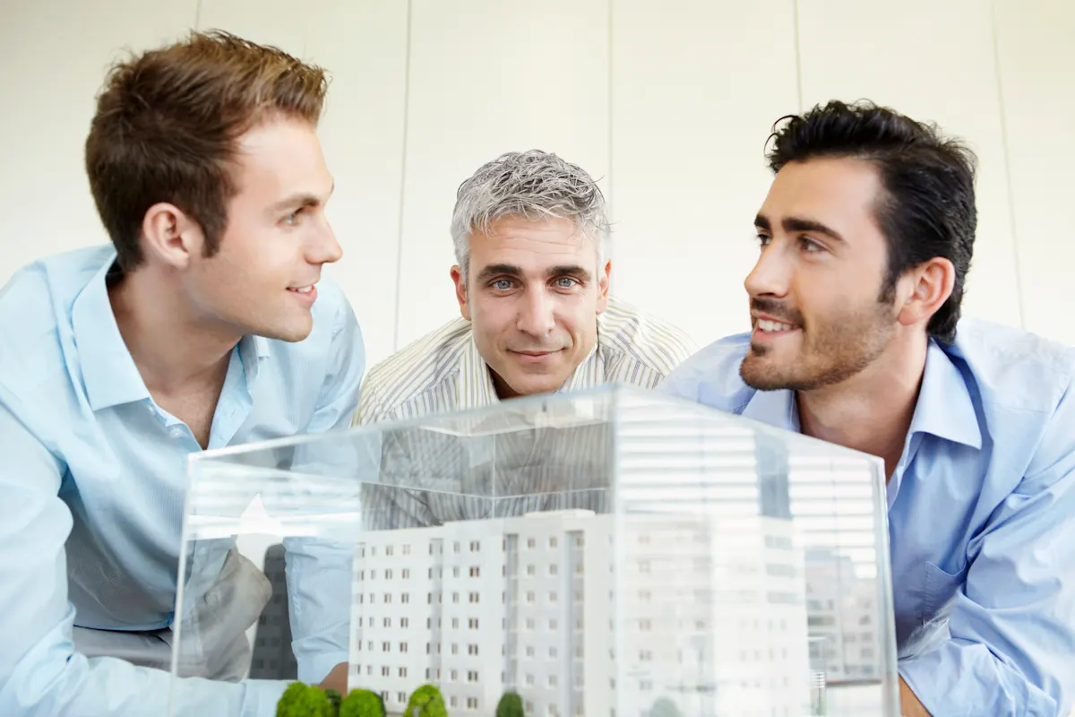 Un groupe d'amis qui regarde une maquette de maison