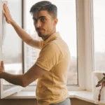 Un homme qui tient une fenêtre double vitrage